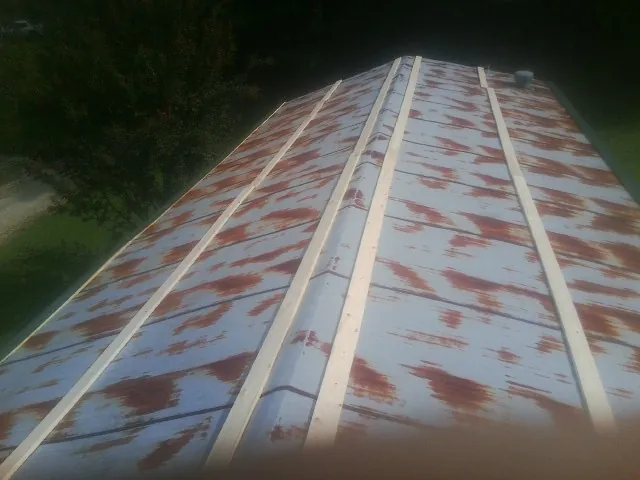 Rusted metal roof panels with new wood purlins before replacement — Storm Damage Roof Repair in Canyon Dam by Roofing Brothers