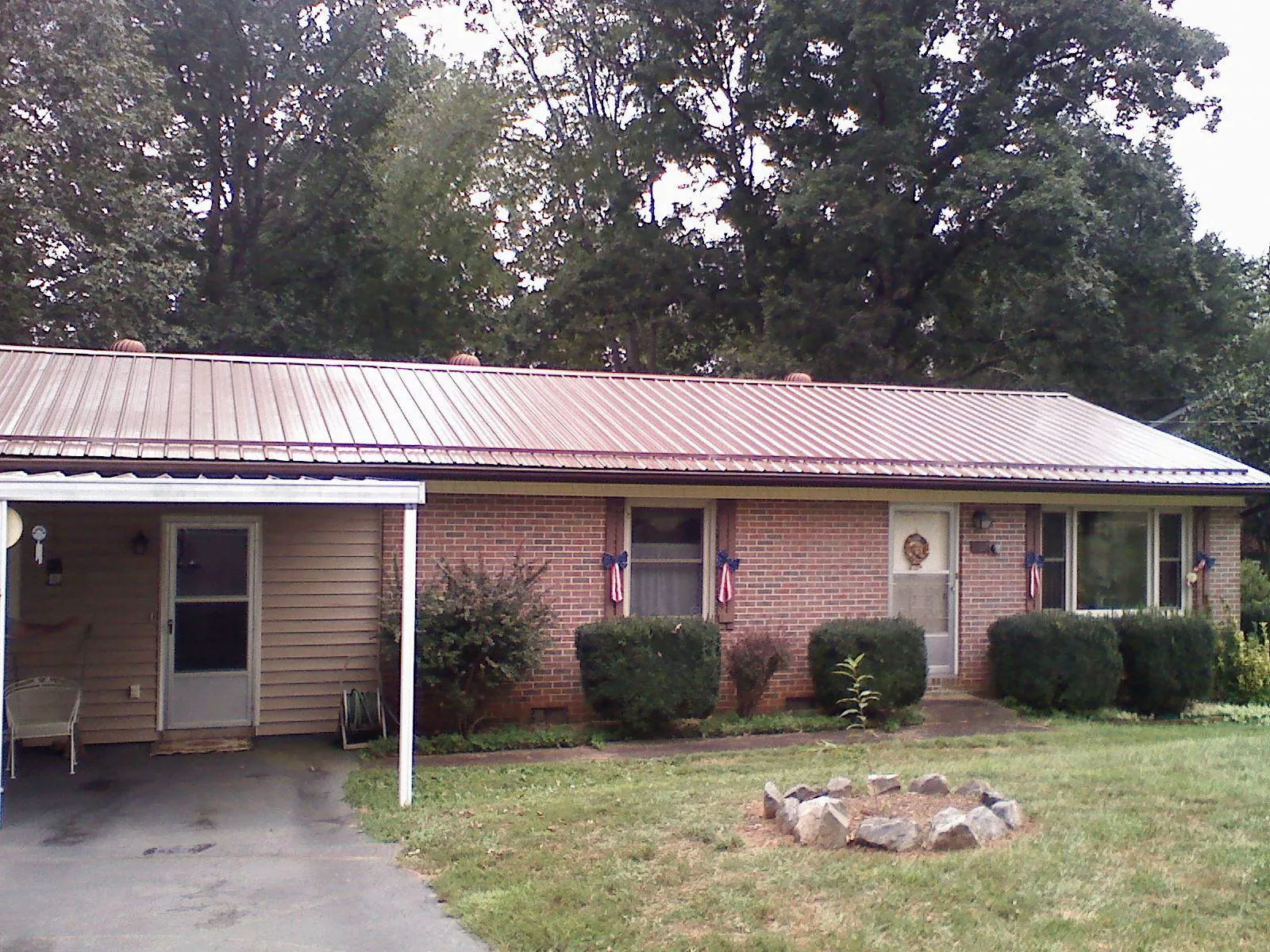 Bronze metal roof and carport on a brick ranch home — Roof Repair work by our crew in Canyon Dam